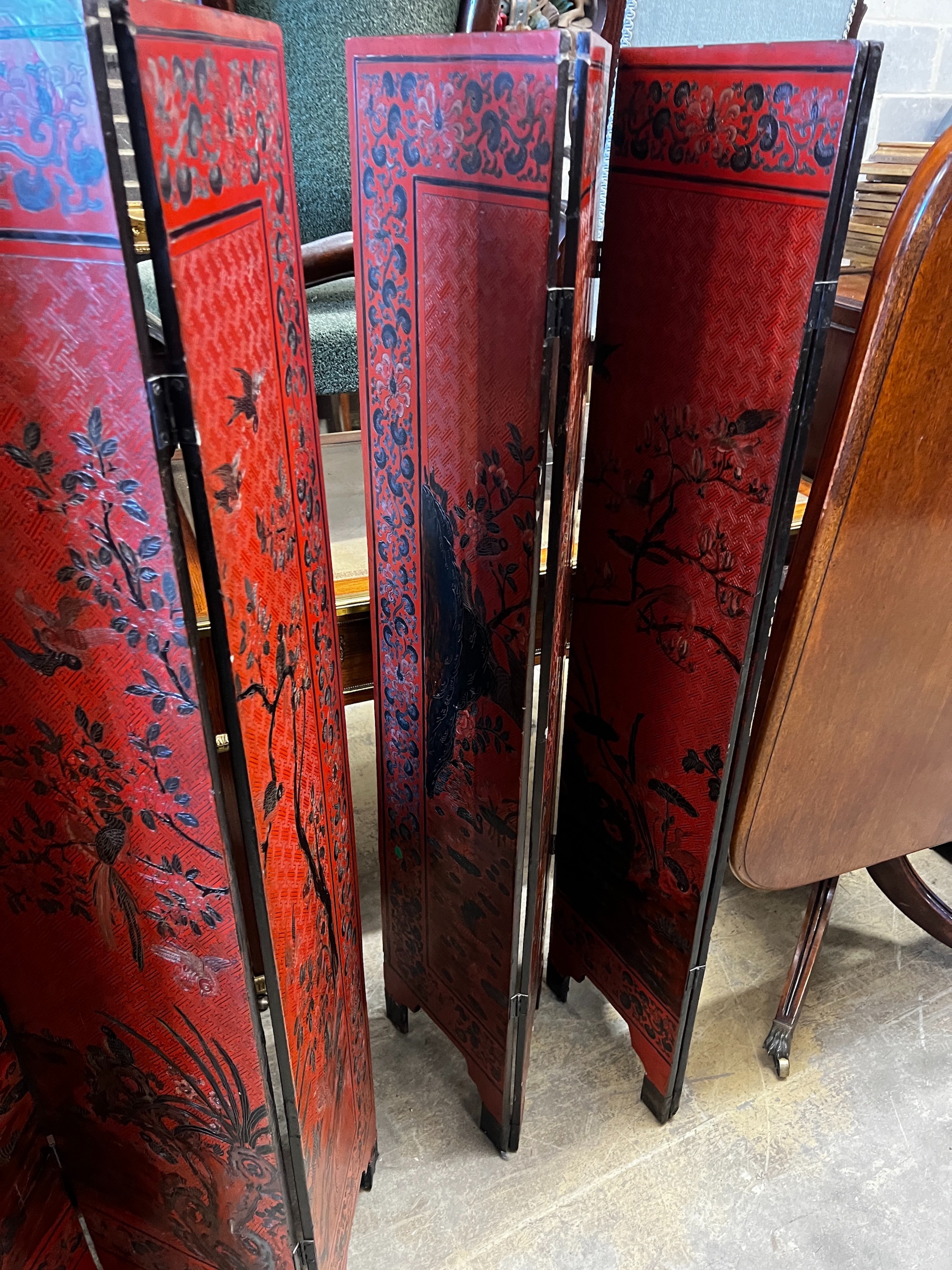 A pair of Chinese four fold lacquer screens decorated with exotic birds amongst branches, each panel width 30cm, height 141cm